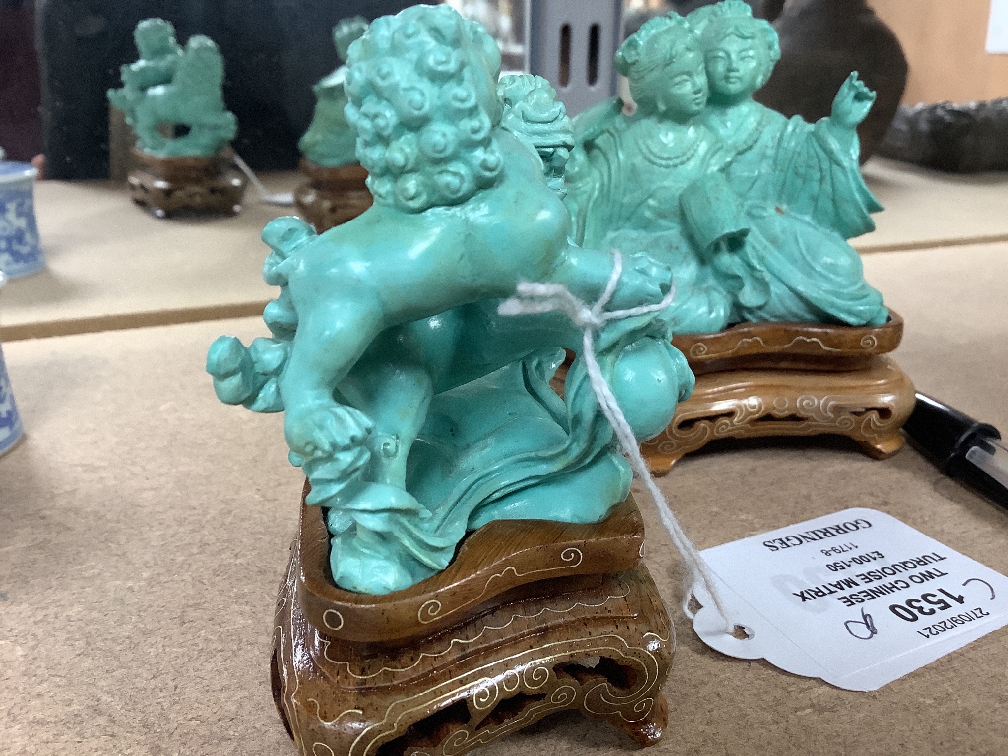 Two Chinese turquoise matrix groups of lion-dogs and of two kneeling ladies, mid 20th century, wood stands, height 9cm